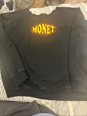 Monet Black Crewneck Sweatshirt with Yellow-Orange Logo